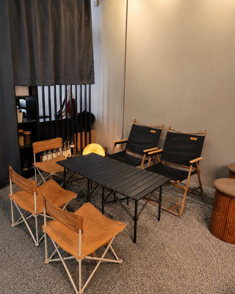 The camping-chair corner at Charming Cafe — folding table and canvas chairs, a quiet spot for long study sessions